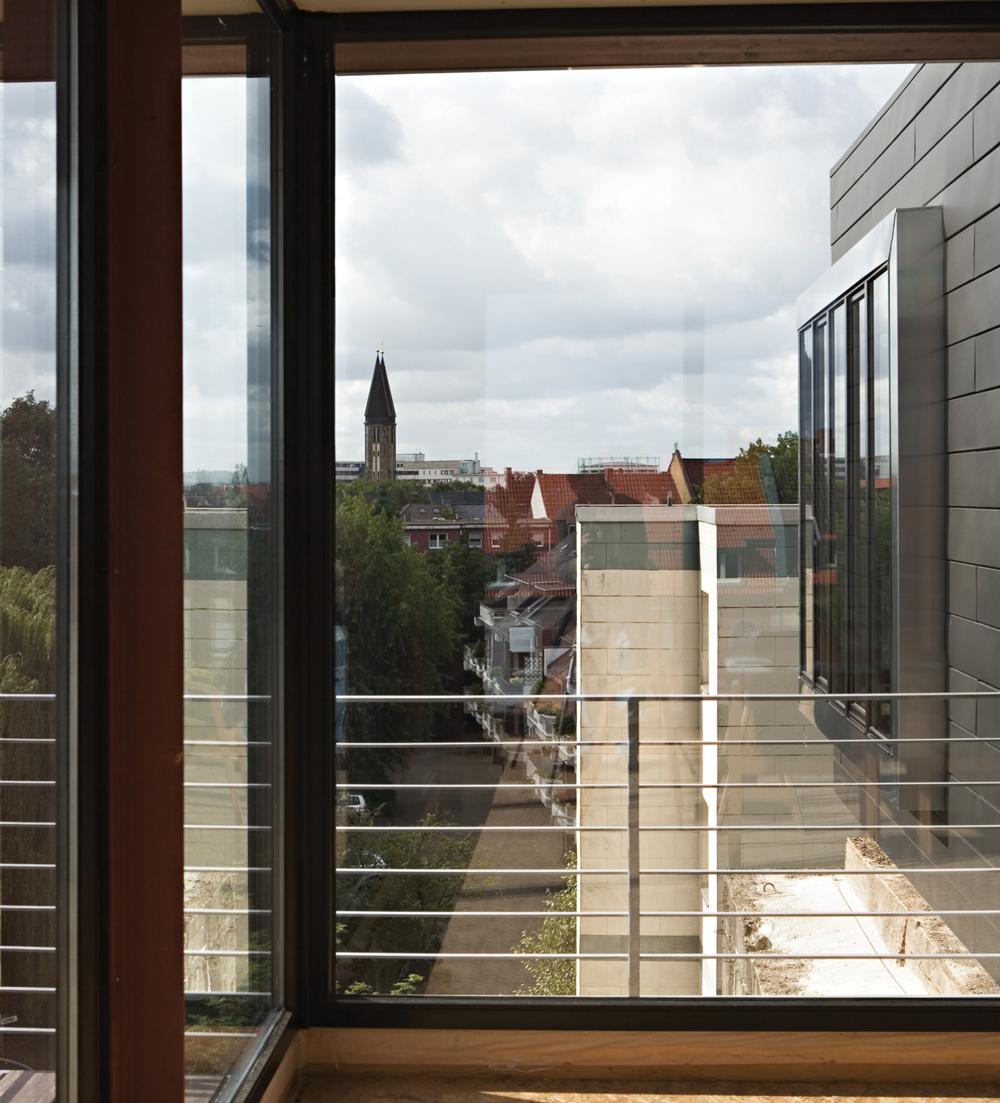 Die Fassade aus vorbewittertem Zinkpaneelen führt die horizontale Struktur fort, die die Schalungsbretter beim Bau des Hochbunkers auf der Bunkerwand hinterlassen haben.