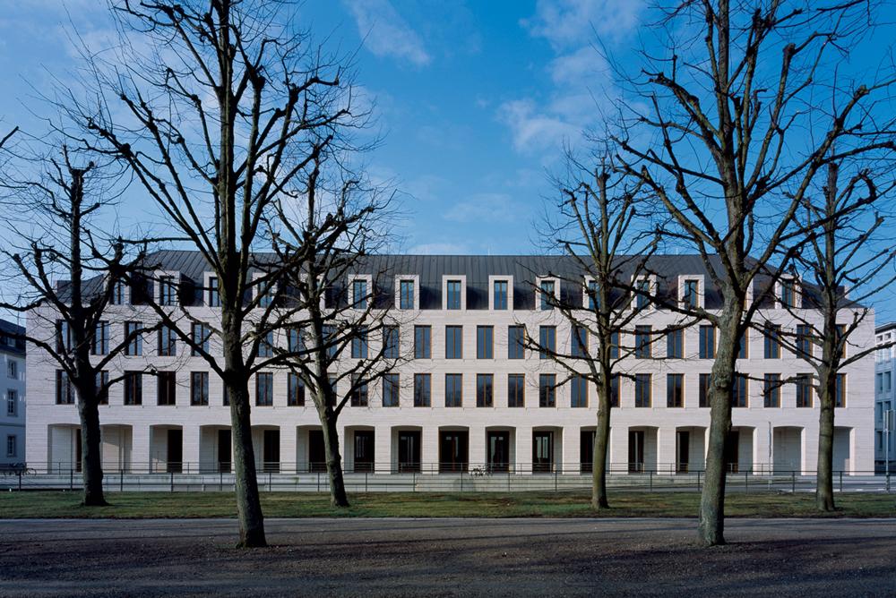 Die Lochfassade der L-Bank orientiert sich an den Gebäuden der Nachbarschaft. Die Schlossplatzfassade ist daher geprägt durch eine eingeschossige Arkade mit flachen Segmentbögen aus Naturstein, die alle Gebäude am Schlossplatz optisch miteinander verbindet.