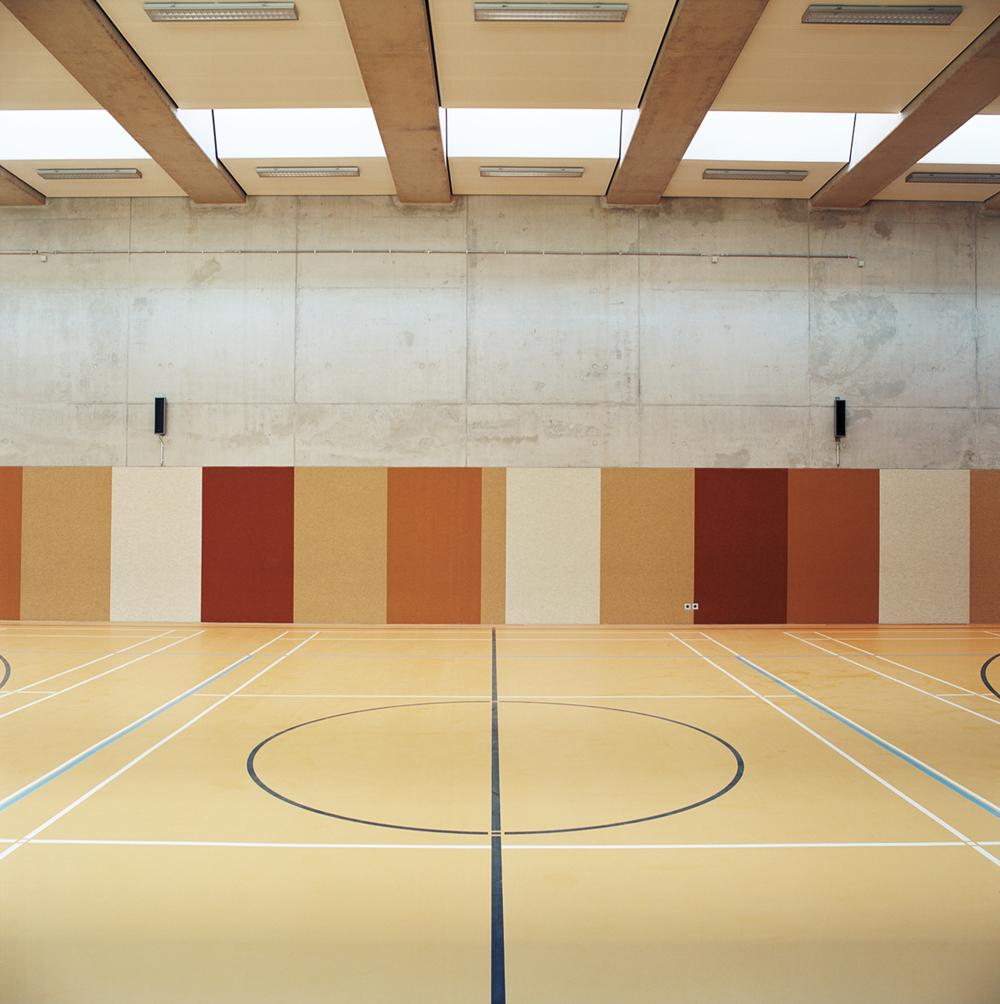 Die Turnhalle wurde platzsparend in die Gebäudekubatur integriert. So ergibt sich ein energetisch sinnvolles Volumen und wertvolle Flächen werden erhalten. Zur  Ressourcenschonung und Nachhaltigkeit trägt zudem die Möglichkeit der Mehrfachnutzung durch Sportvereine in den Abendstunden und am Wochenende bei.
