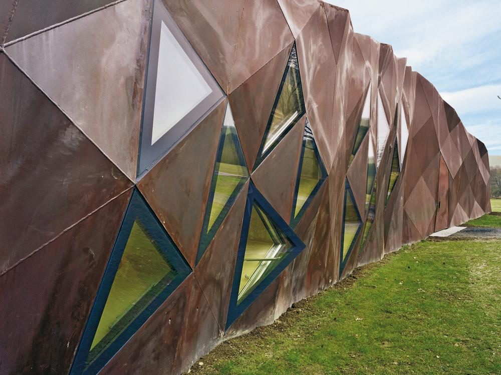 Dokumentationszentrum in Hinzert, Architekten: Wandel Hoefer Lorch + Hirsch; hervorstehende Fugen betonen den rohen Charakter der Hülle aus verschweißten Platten aus wetterfestem Stahl.