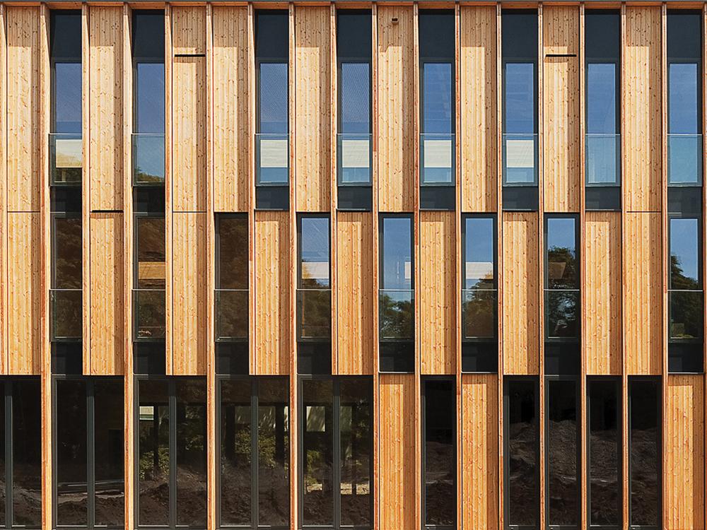Die Fassade ist als vertikale Bretterverschalung nach dem Prinzip der Opferholzkonstruktion  umgesetzt.