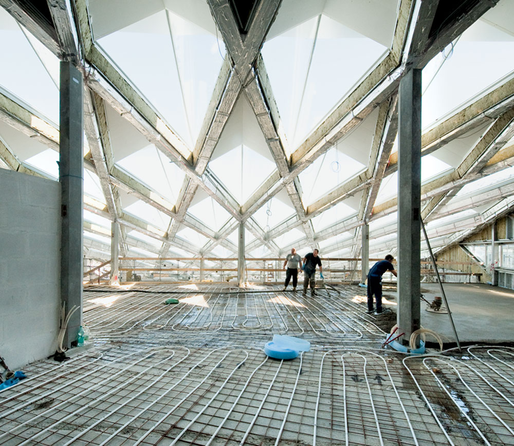 Büroebenen in der Bauphase. Auf der Geschossdecke sind die Schläuche der Bauteilkühlung zu sehen.