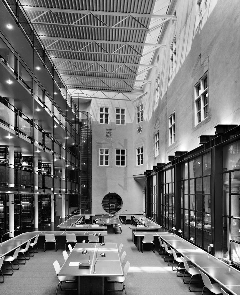 Umbau des Ulmer Hofs zum Fachbereich Katholische Theologie, 1978 –1980: Der offene Hof wird durch den Einbau der Bibliothek zu einem hallenartigen Lesesaal, ein Außenraum zum überdachten Innenraum.