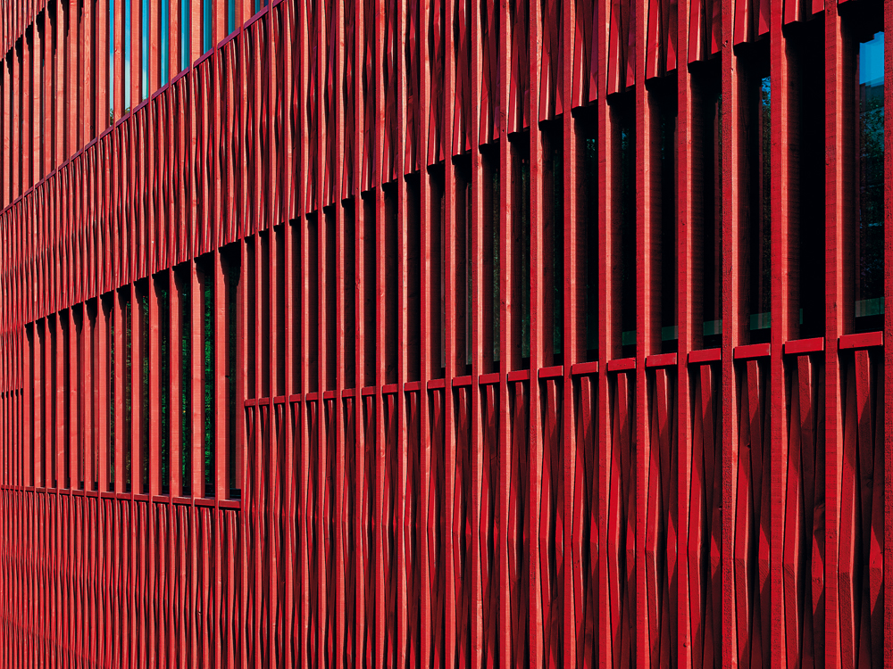 zweischichtiger Auftrag unterschiedlicher Rottöne auf sägerauer Weißtannenschalung, Schule in Büttenen, Architekten: Rohrer Sigrist