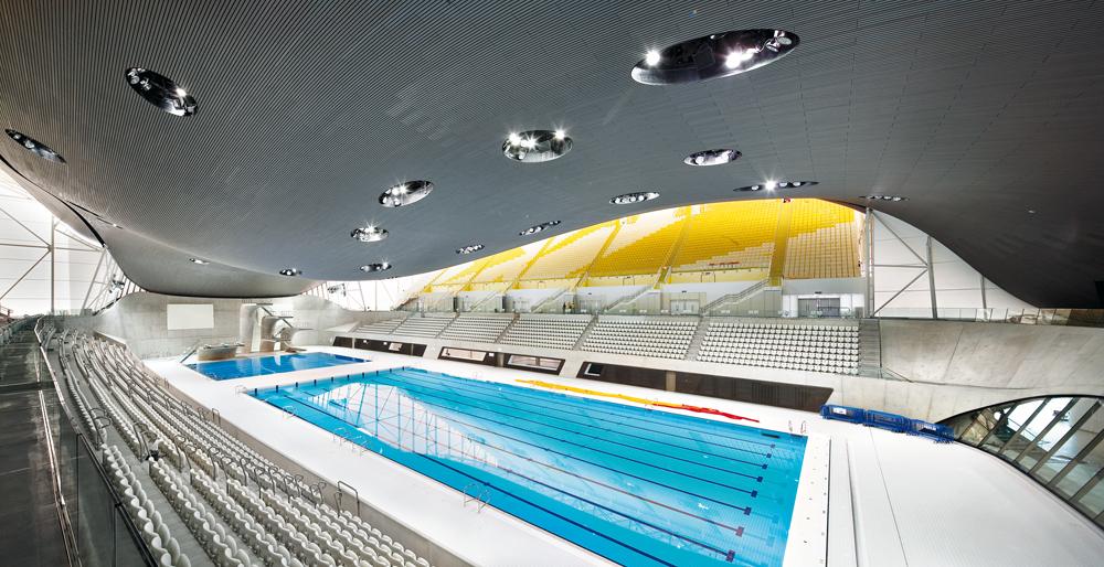Schwimmhalle
Architekten: Zaha Hadid Architects
Die temporären Zuschauertribünen werden nach den Olympischen Spielen demontiert und durch Glasfassaden ersetzt.