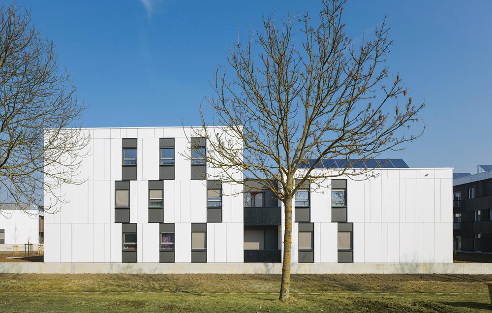 Südansicht mit den mit hellgrauem Faserzement verkleideten »Energiebügeln«