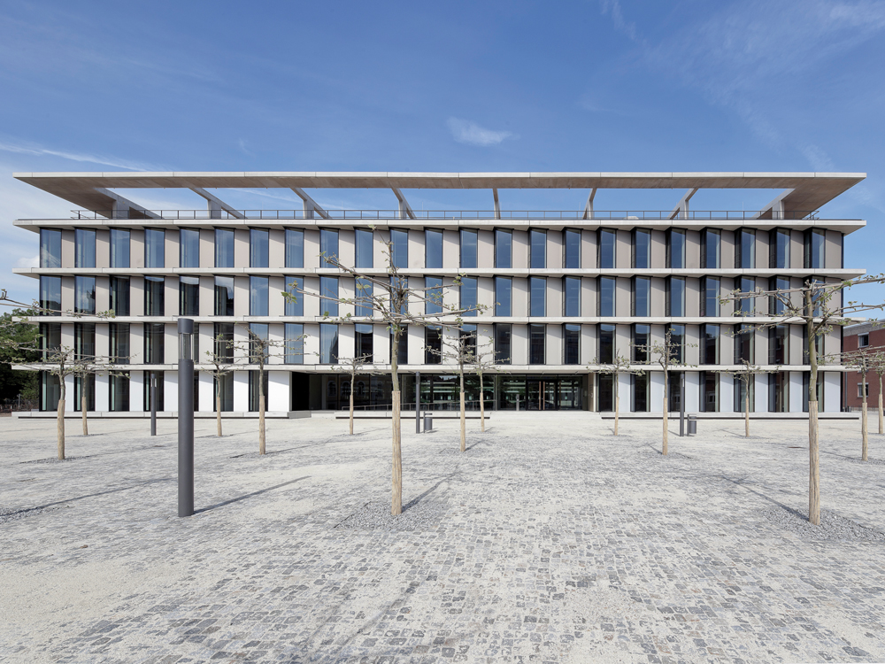 Aufgelockerte Strenge: Die Loggien im Dachgeschoss und die reliefartig ausgebildete Fassade suchen die Anbindung an den Stadtraum. Die Platanen auf dem Vorplatz werden zu einem geschlossenen Dach zusammenwachsen und somit eine zusätzliche Verbindung zwischen den Neubauten und der angrenzenden historischen Bebauung schaffen.