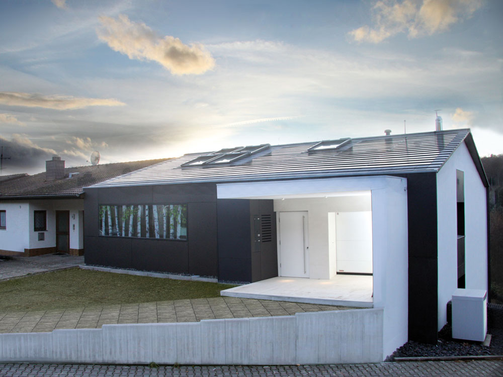 Die Dachflächenfenster und die Photovoltaik-Module sind geschickt in die Dachfläche integriert.