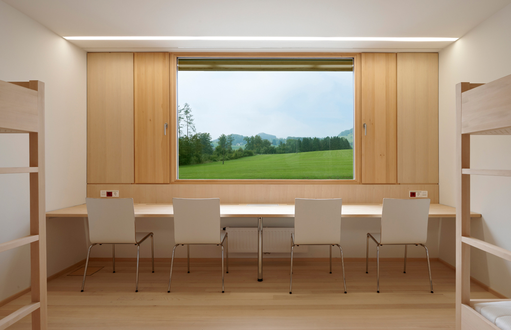 Vierbettzimmer im Internatsflügel. Die Lüftungsflügel zu beiden Seiten der Fenster lassen sich manuell öffnen.
