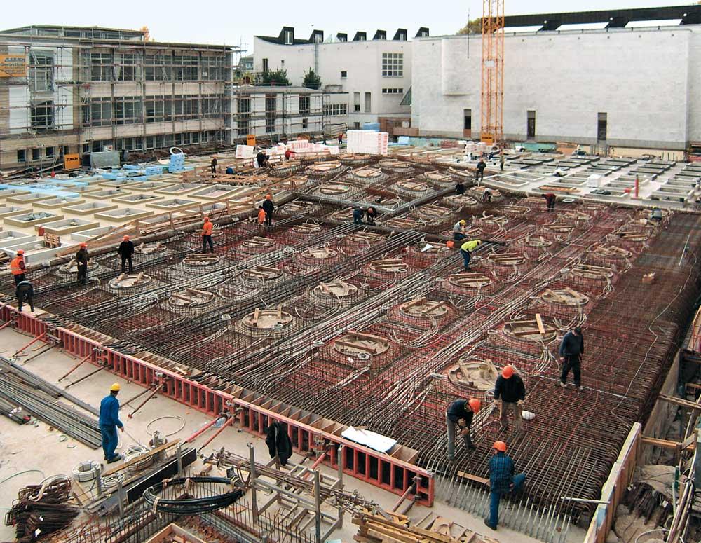 verschiedene Bauabschnitte der Dachdecke des Erweiterungsbaus: Schalung mit Bewehrung, Spannkabeln, Betonkernaktivierung und Leerrohren; Aufkantungen der Oberlichter nach dem Betonieren; Dämmung der Dachdecke