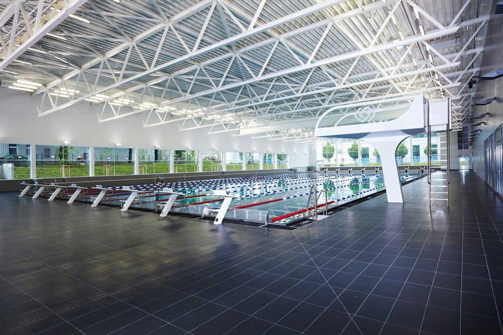 Das sichtbare Dachtragwerk unterstützt den offenen, hellen Charakter der großen Schwimmhalle.
