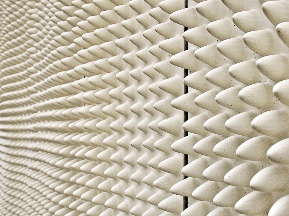 Die Fassadenplatten aus Betonwerkstein in Anlehnung an DIN 18516 beruhen auf einer künstlerischen Idee von Judith Runge.