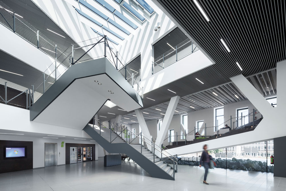 Das mehrgeschossige Atrium erhält durch ein Glasdach viel Tageslicht von oben. Es kann als Ort für Veranstaltungen genutzt werden.