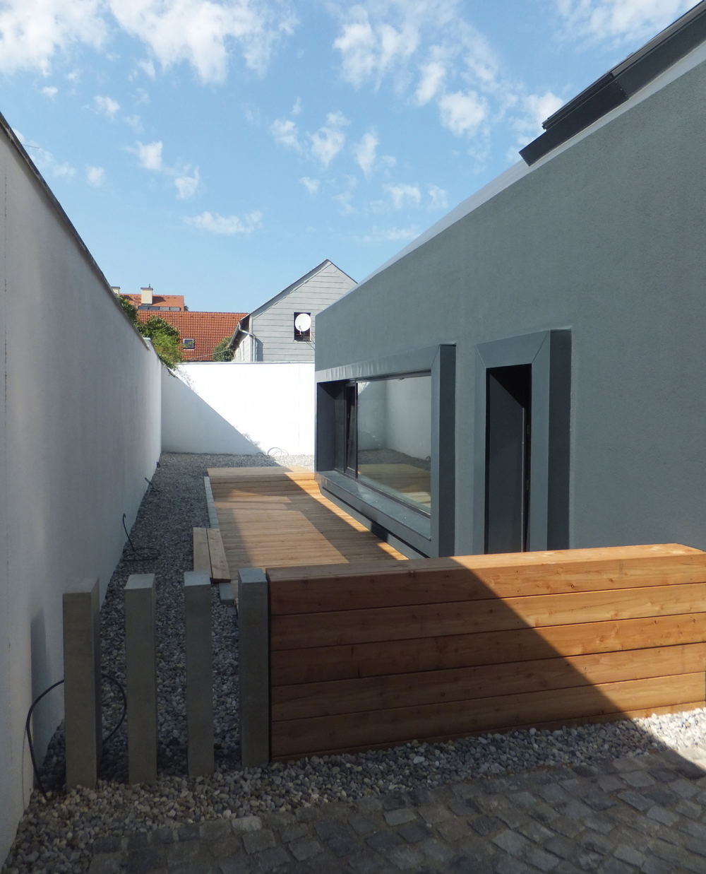 Mit der monolithisch wirkenden anthrazitfarbenen Außenhülle setzt sich das kleine Architekturbüro deutlich von der Bebauung in der Nachbarschaft ab.