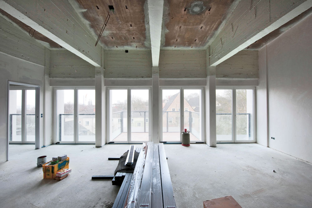 Dachgeschosswohnung während des Umbaus. In den meisten Wohnungen verschwanden die Dachbalken aus Beton auf Wunsch der Bewohner wieder hinter einer Gipskartondecke.