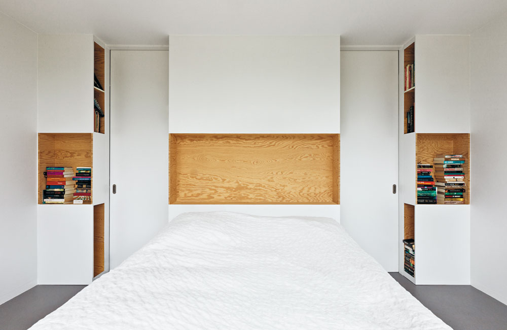 Für »Home 09« verwendeten i29 Seekieferplatten, die mit ihrer fladerigen Oberfläche den Innenräumen ein wiederkehrendes Motiv verleihen. Es handelt sich dabei um verhältnismäßig günstige Mehrschichtplatten, die auch für Schalungen oder Bautischlerarbeiten genutzt werden. Gestalterisch konsequent werden die Möbel auf Gehrung gefügt oder die Kanten beschichtet, um das Oberflächenbild fortzuführen.