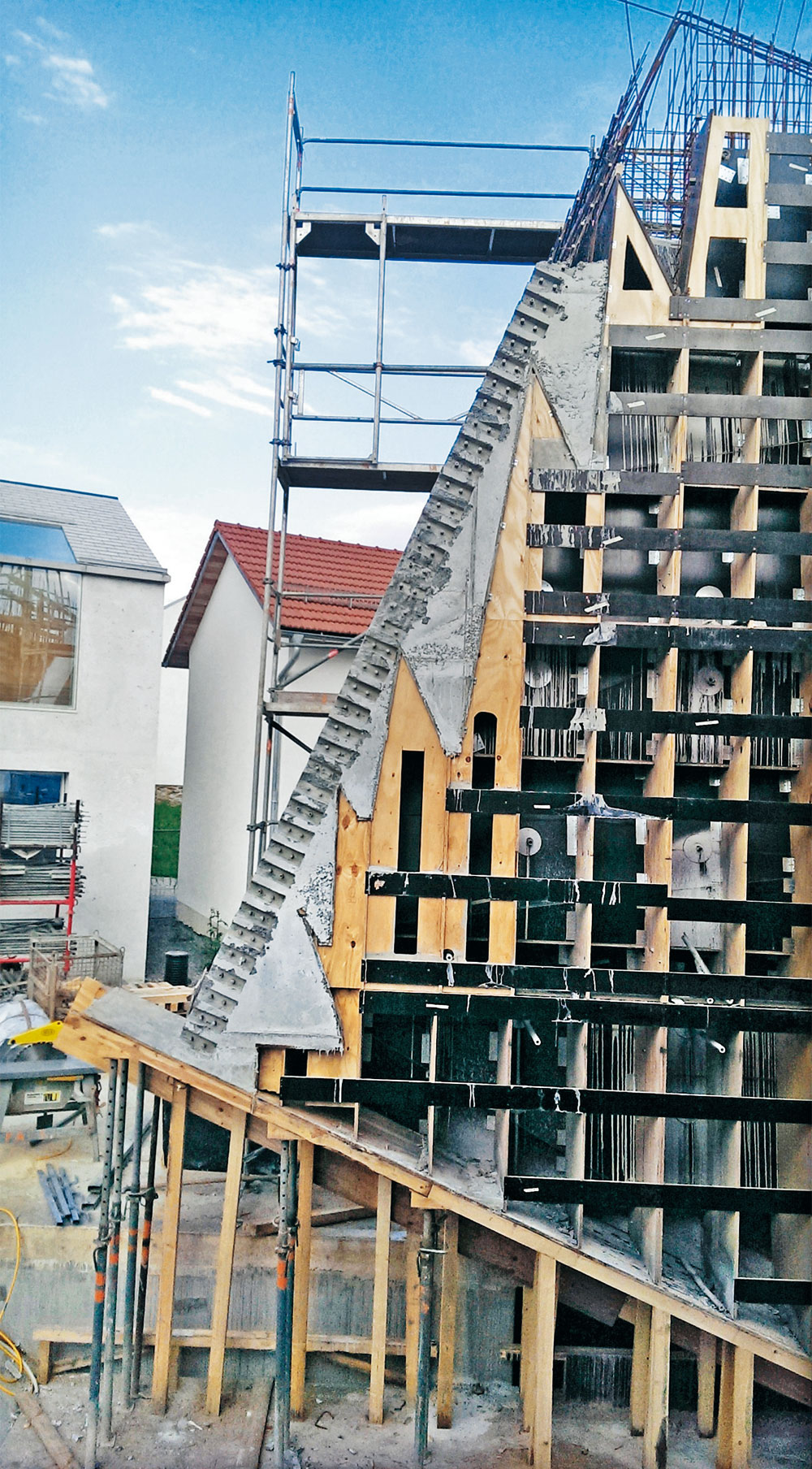 Seitenwand des Vortragssaals vor Entfernung der Schalungselemente und verzahnte Fuge mit Bewehrungsschraubstoß für die Rückwand
