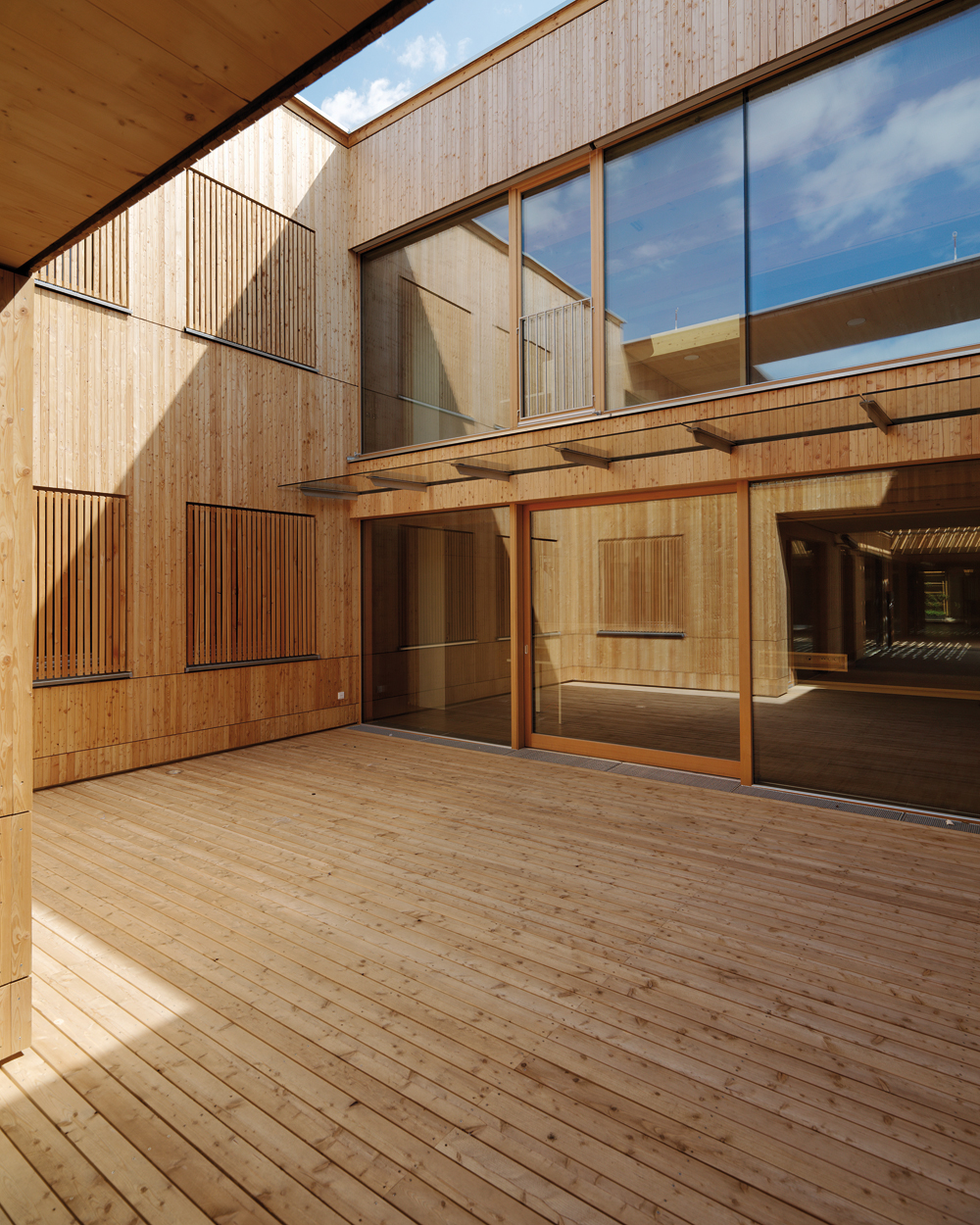 Holz ist der gestaltgebende Werkstoff des Gebäudes. Mit ihm ließ sich nicht nur ökonomisch konstruieren, sondern auch eine angenehme und freundliche Atmosphäre erzeugen.