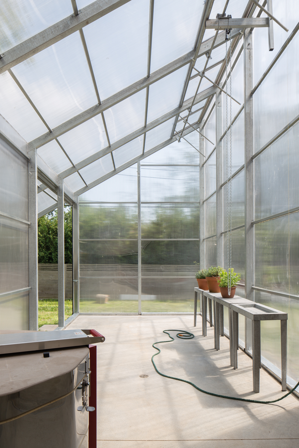 Die transluzente Hülle des Gewächshauses besteht aus doppelwandigen Polycarbonat-Paneelen und gibt so einen schemenhaften Blick ins Innere und auf die verzinkte Tragstruktur preis.