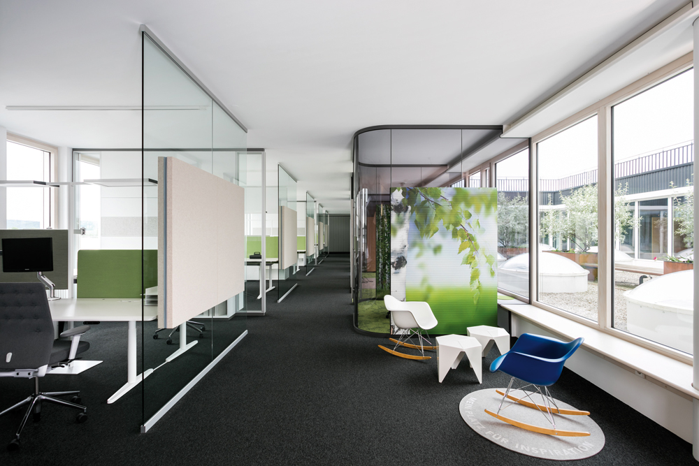 Der Grundriss gruppiert sämtliche Funktionen um einen offenen Innenhof. Die Teamarbeitsplätze sind nach außen, entlang der Fassade angeordnet. Die verglasten Boxen für konzentriertes Arbeiten sowie die offenen Flächen für den schnellen Gedankenaustausch orientieren sich zum Hof. Dieser ist begehbar und erweitert das Raumangebot um einen Außenbereich.