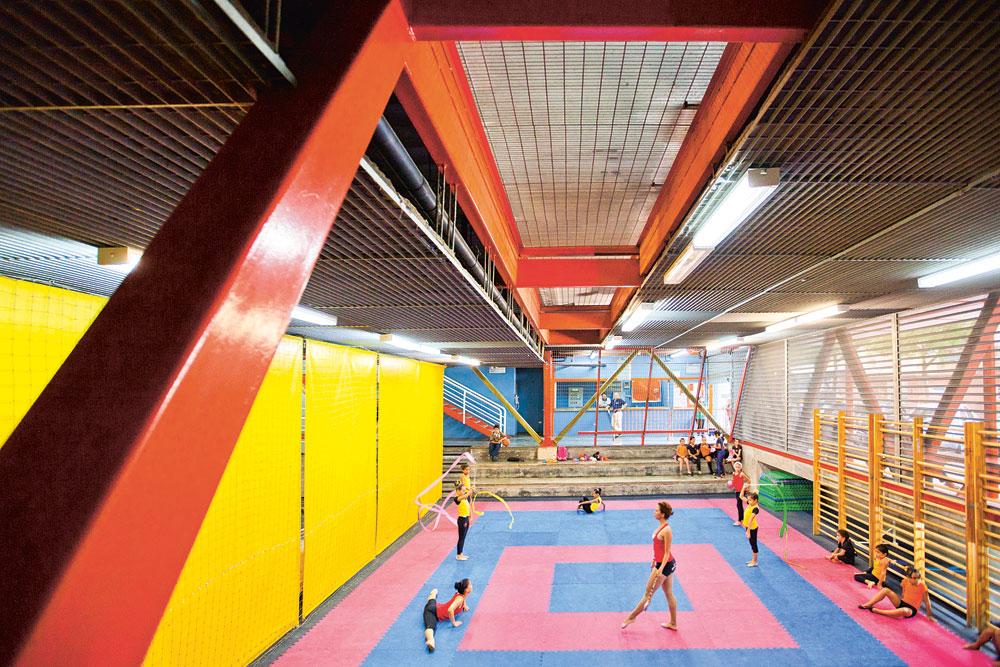 Sportzentrum in Caracas (VE), Urban-Think Tank 2004. Mit seinem »Vertical Gym Chacao« schuf das Büro Urban-Think Tank einen neuen Typ Sportzentrum mit vertikal gestapelten Nutzungen für die dicht bebauten Armensiedlungen Lateinamerikas. Er basiert auf einem modularen Baukastensystem mit Stahlskelett, das sich flexibel an die jeweiligen Standortbedingungen und die gewünschte Nutzungskombination anpassen lässt. In der Zwischenzeit hat Urban-Think Tank drei weitere »Vertical Gyms« an anderen Stellen des Landes errichtet.
