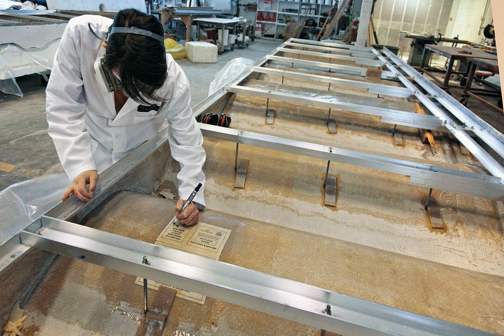 Produktion der GFK-Paneele
nach dem Laminieren der Glasfaserlagen mit Handrollern wird die Rückseite des Paneels mit Aluminiumprofilen verstärkt