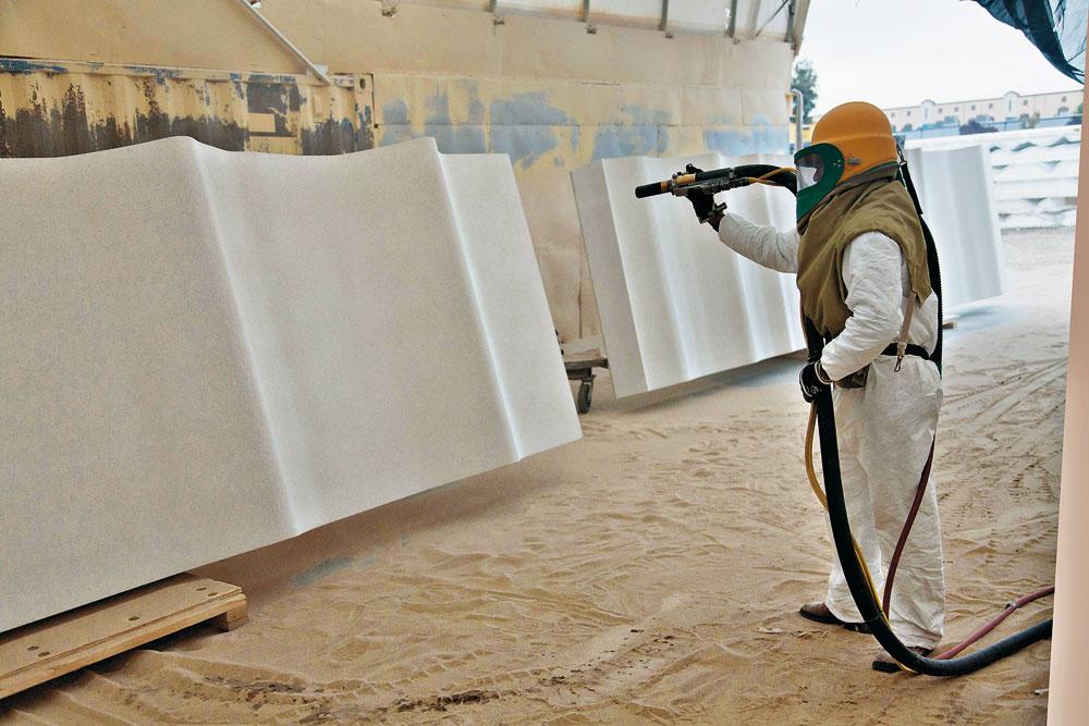 Produktion der GFK-Paneele
Sandstrahlen der mit Gelcoat beschichteten Paneele, um eine raue Oberfläche zu erhalten.