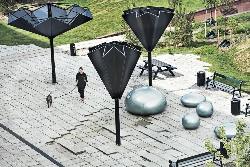 Beim Taasinge Plads in Kopenhagen nutzten die Landschaftsarchitekten GHB Regenwasser als spiele­risches Element. Ein begrüntes Rückhaltebecken nimmt das vom Platz ablaufende Wasser auf. Regenwasser von den umliegenden Hausdächern gelangt in ein unterirdisches Reservoir. Von dort kann es mittels kippbarer Elemente im Pflasterbelag zurück an die Oberfläche gepumpt werden.