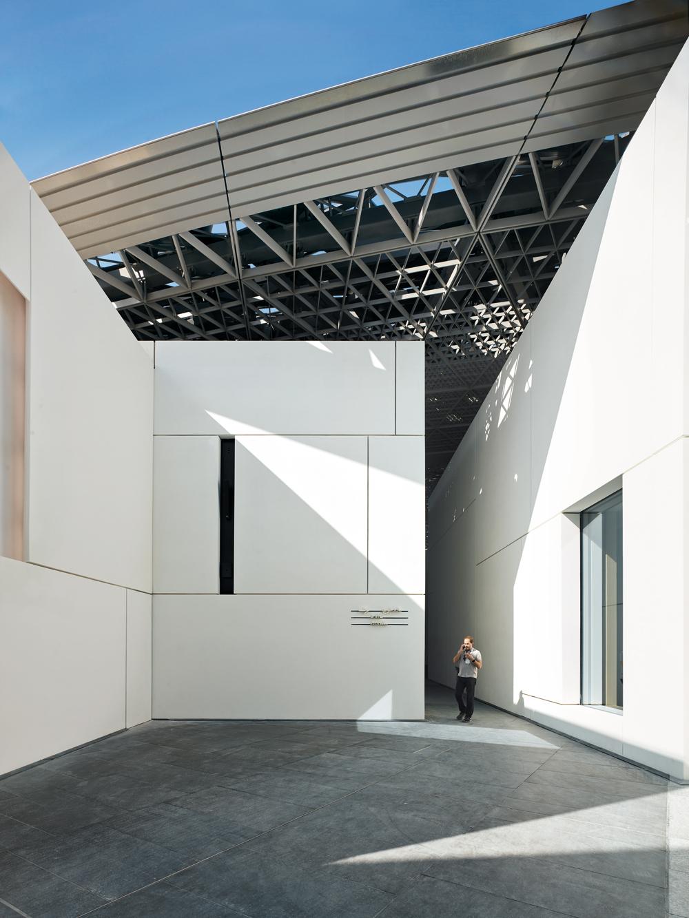 Die Struktur der Aluminiumverkleidungen der Stahlkuppel steht in spannungsreichem Kontrast zur orthogonalen Geometrie der weißen Faserbetonfassaden.