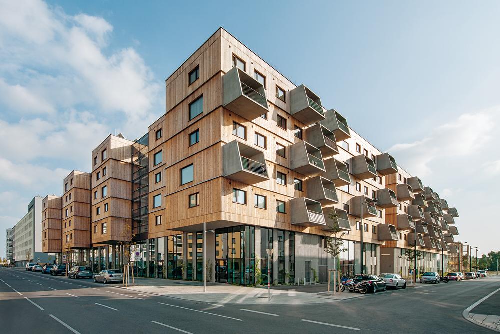 Holzwohnbau von Berger+Parkkinen Architekten und querkraft Architekten in der Seestadt Aspern: Die 2015 fertiggestellte Anlage fasst neben Wohnungen zwischen 42 und 110 Quadratmetern auch Geschäfts- und Gemeinschaftsflächen. Der Innenhof ist das lebendige Zentrum des großen Wohnkomplexes.