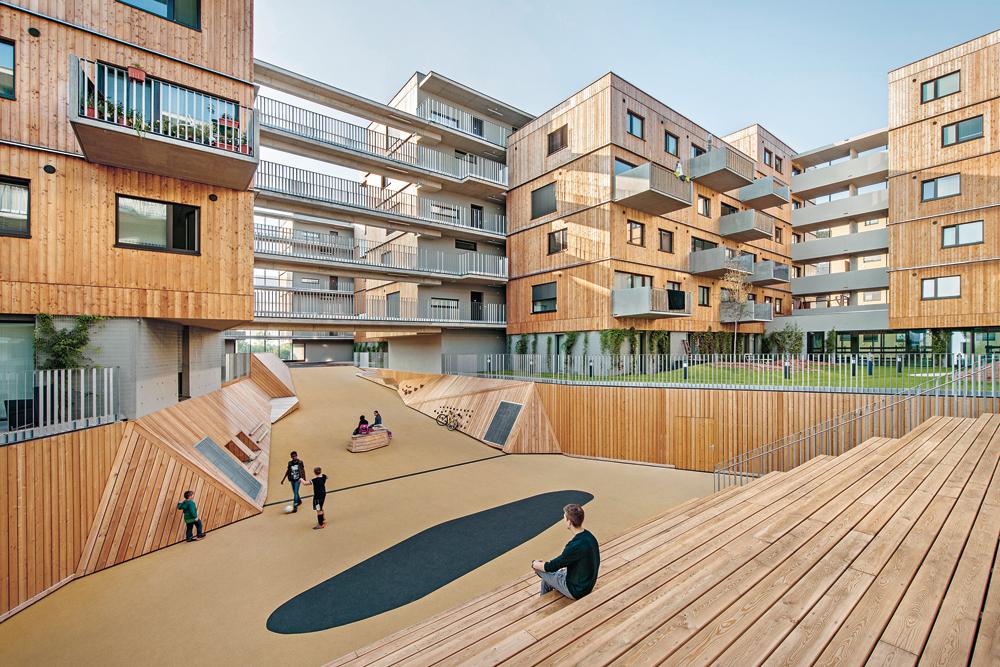 Holzwohnbau von Berger+Parkkinen Architekten und querkraft Architekten in der Seestadt Aspern: Die 2015 fertiggestellte Anlage fasst neben Wohnungen zwischen 42 und 110 Quadratmetern auch Geschäfts- und Gemeinschaftsflächen. Der Innenhof ist das lebendige Zentrum des großen Wohnkomplexes.