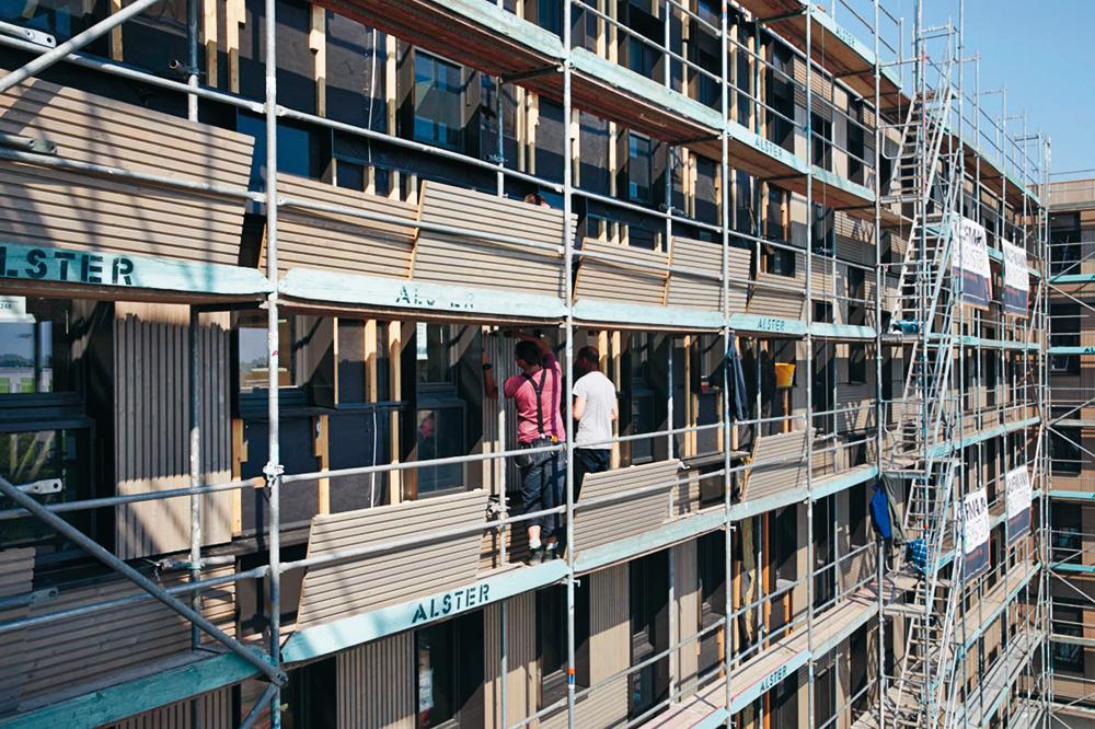 Während die Unterkonstruktion der Fassade bereits im Werk aufgebracht wurde, erfolgte die Montage der vorvergrauten Lärchenholzpaneele vor Ort auf der Baustelle.