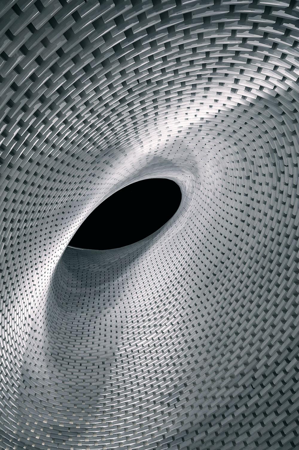 Die strudelartige Skulptur in der Mitte der Andachtshalle besteht aus 30 x 40 x 10 cm großen Aluminium-Blöcken, die auf Grundlage eines präzisen 3D-Modells gestapelt und miteinander verschraubt wurden.