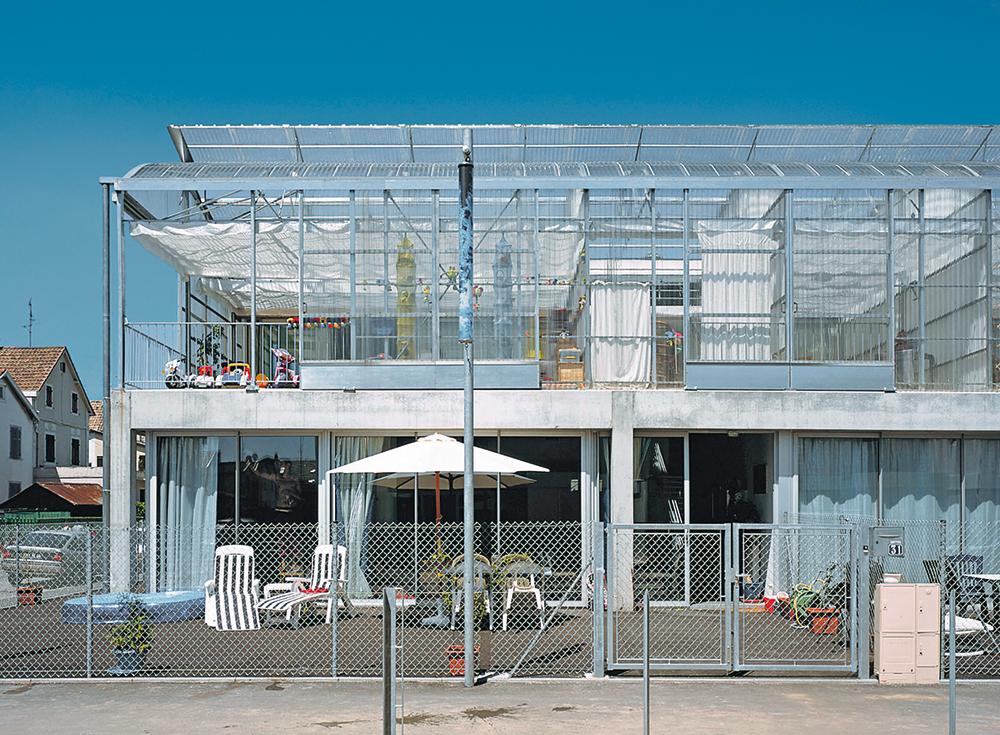 Sozialer Wohnungsbau, Cité Manifeste, Mulhouse, 2005. Filigrane Stahlgerüste mit transparenter und gewellter Polycarbonatverkleidung sowie einfache Entlüftungsmechanik führen die Prinzipien von Gewächshäusern im Wohnbau fort.