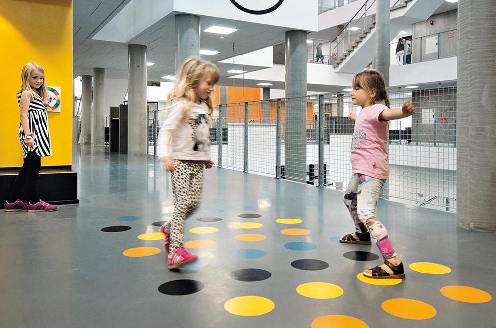 Überall im Gebäude finden die Kinder Anregung, sich zu bewegen. Langweilige Flure verwandeln sich zur Rennstrecke, Treppen zum Klettergerüst und Garderoben zur Trimm-Dich-Station mit Tau oder Ringen.