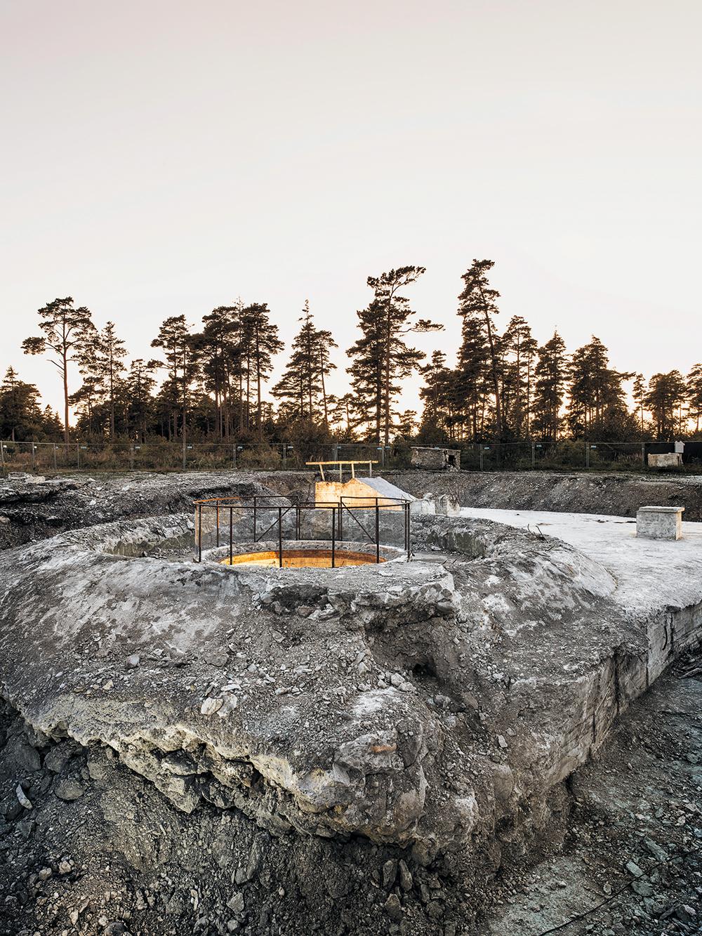 Drei Geschosse tief in die Erde reicht der Geschützbunker, den Skälsö Arkitekter durch einen Neubau ergänzten und zum Sommerhaus umgebaut haben. Die kreisrunde Öffnung dient heute als Oberlicht für ein unterirdisches Spa.