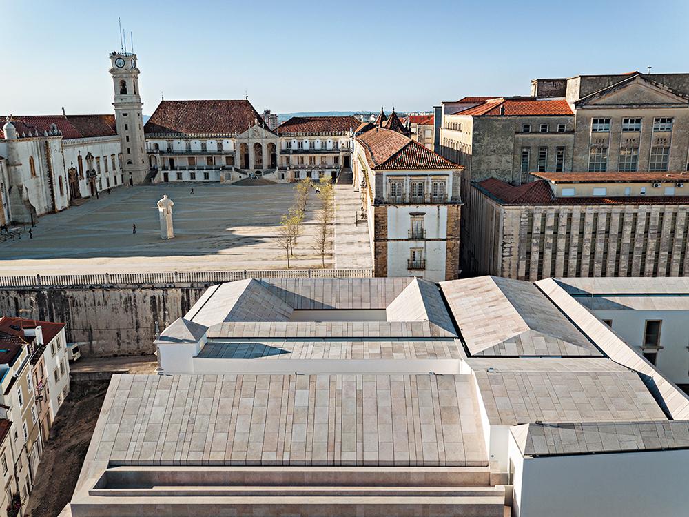 Neben dem Colégio befindet sich der Palacio de las Escuelas mit seinem großen Patio. Die Architekten nahmen den Platz als Motiv in der Dachlandschaft aus dünnen Kalksteinplatten auf. Die Oberlichter trennen Alt von Neu.