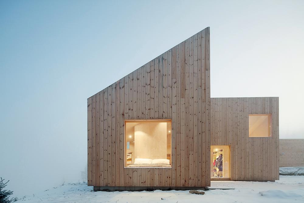 Im klar geschnittenen Baukörper des hochdämmten Holzhauses holen große Glasflächen eine Fülle von Tageslicht in die offenen, fließenden Raumbereiche und bieten weite Ausblicke auf den Mylla-See und die umgebenden Wälder.
