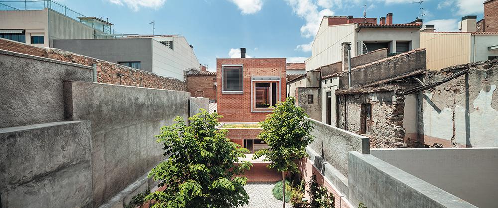 Wie Passepartouts rahmen vorgesetzte Sonnenschutzelemente die Fenster in der Gartenfassade des Hauses in Granollers. Im Mauerwerk kombinierten die Architekten zwei Ziegeltypen mit unterschiedlicher Dichte und Tragfähigkeit.