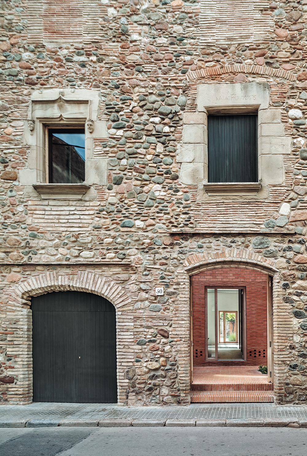 Nur 6,5 m schmal, aber sehr tief ist die Parzelle hinter dieser Altbaufassade in Granollers. Harquitectes bebauten sie mit einem zweiteiligen Wohnhaus mit mehreren Innenhöfen und überdachtem Freisitz.
