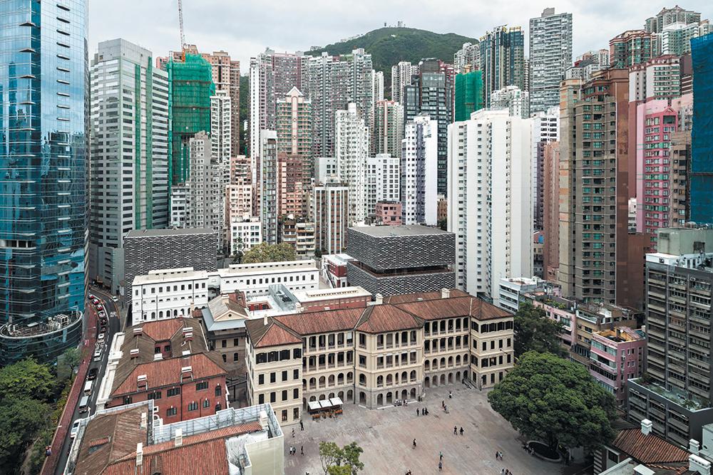 Hochhäuser flankieren das einstige Polizeiviertel in Hongkong. Module aus recyceltem Aluminium bilden die neuen Fassaden des Kulturzentrums.
