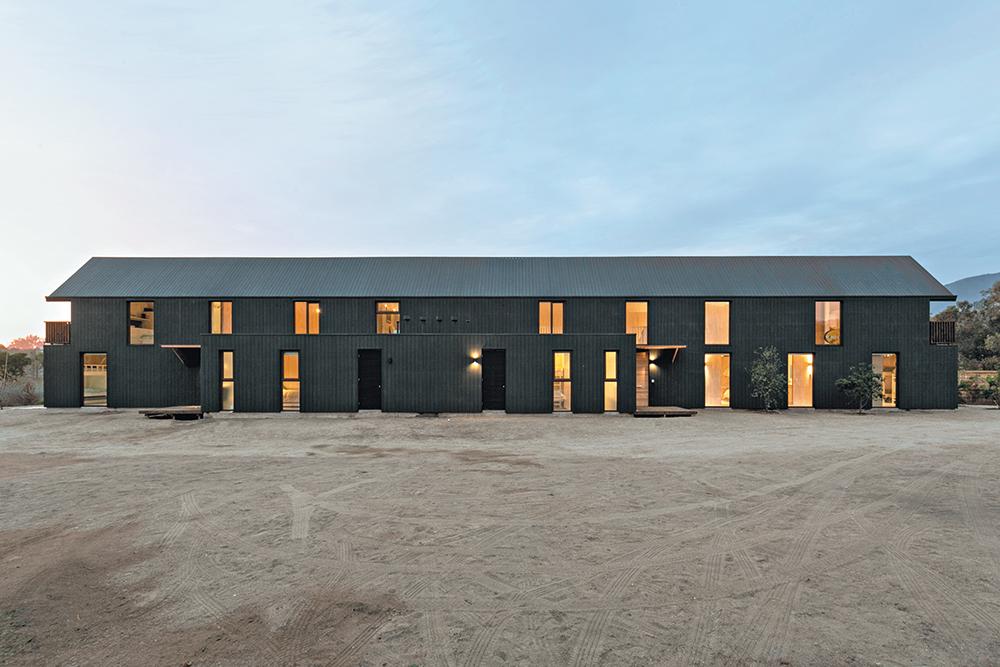 Das Doppelhaus besteht bis auf die Bodenplatte komplett aus Sandwichpaneelen, sogenannten Structural Insulated Panels. Außen erhielt es eine dunkle Faserzementverkleidung.