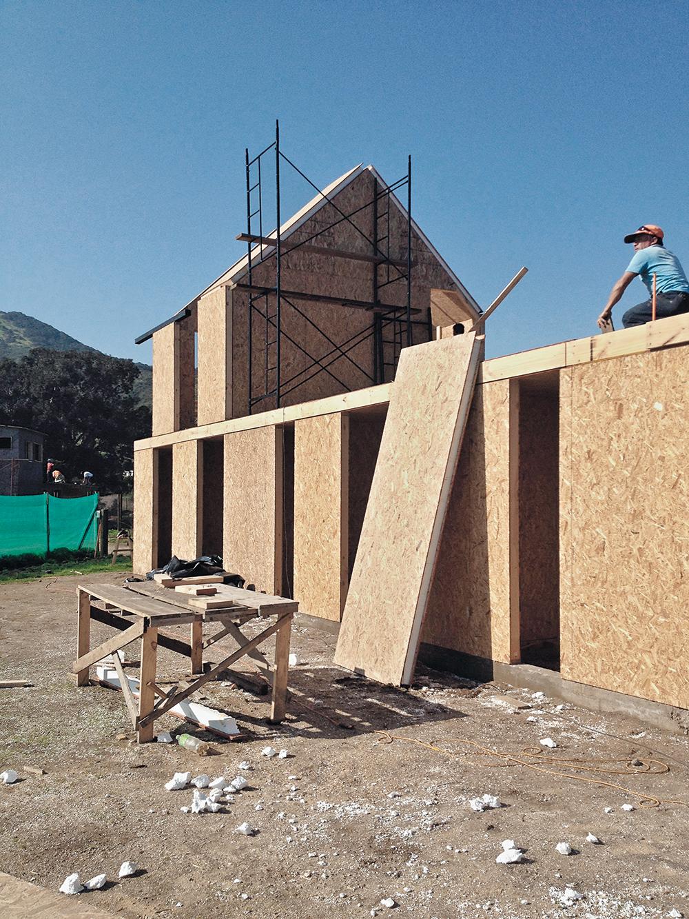 Das Doppelhaus besteht bis auf die Bodenplatte komplett aus Sandwichpaneelen, sogenannten Structural Insulated Panels. Außen erhielt es eine dunkle Faserzementverkleidung.