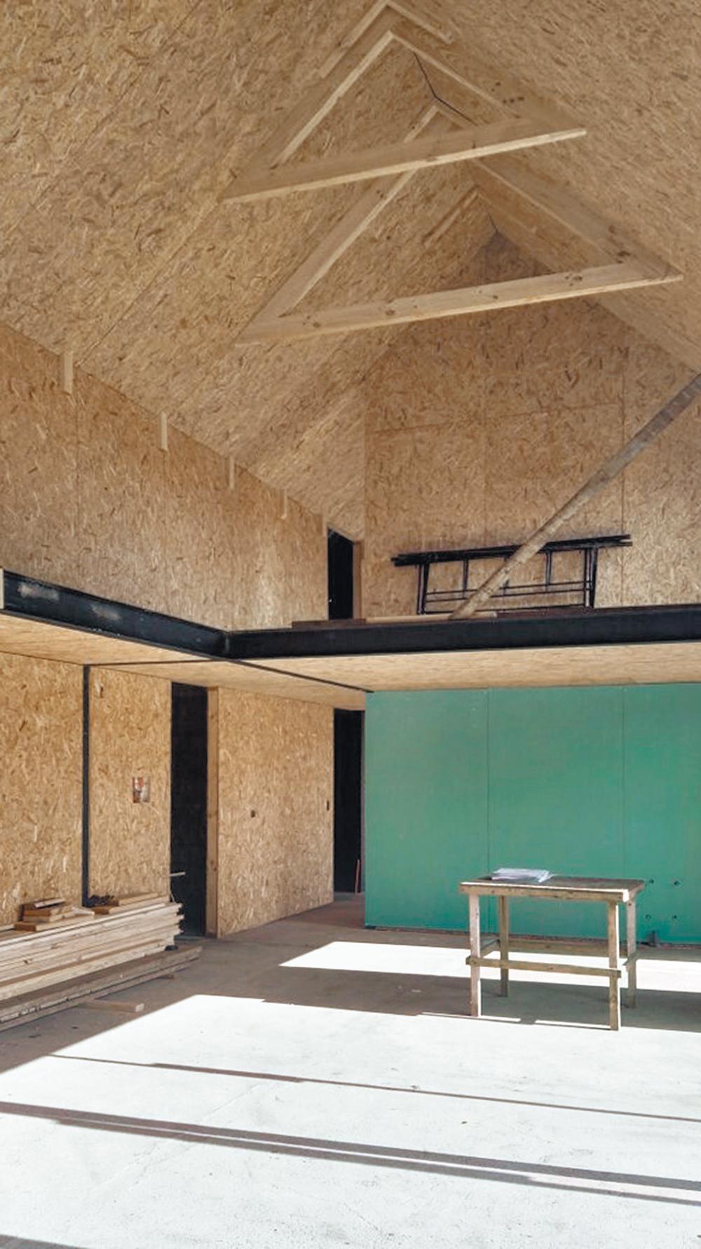 Das Doppelhaus besteht bis auf die Bodenplatte komplett aus Sandwichpaneelen, sogenannten Structural Insulated Panels. Außen erhielt es eine dunkle Faserzementverkleidung.