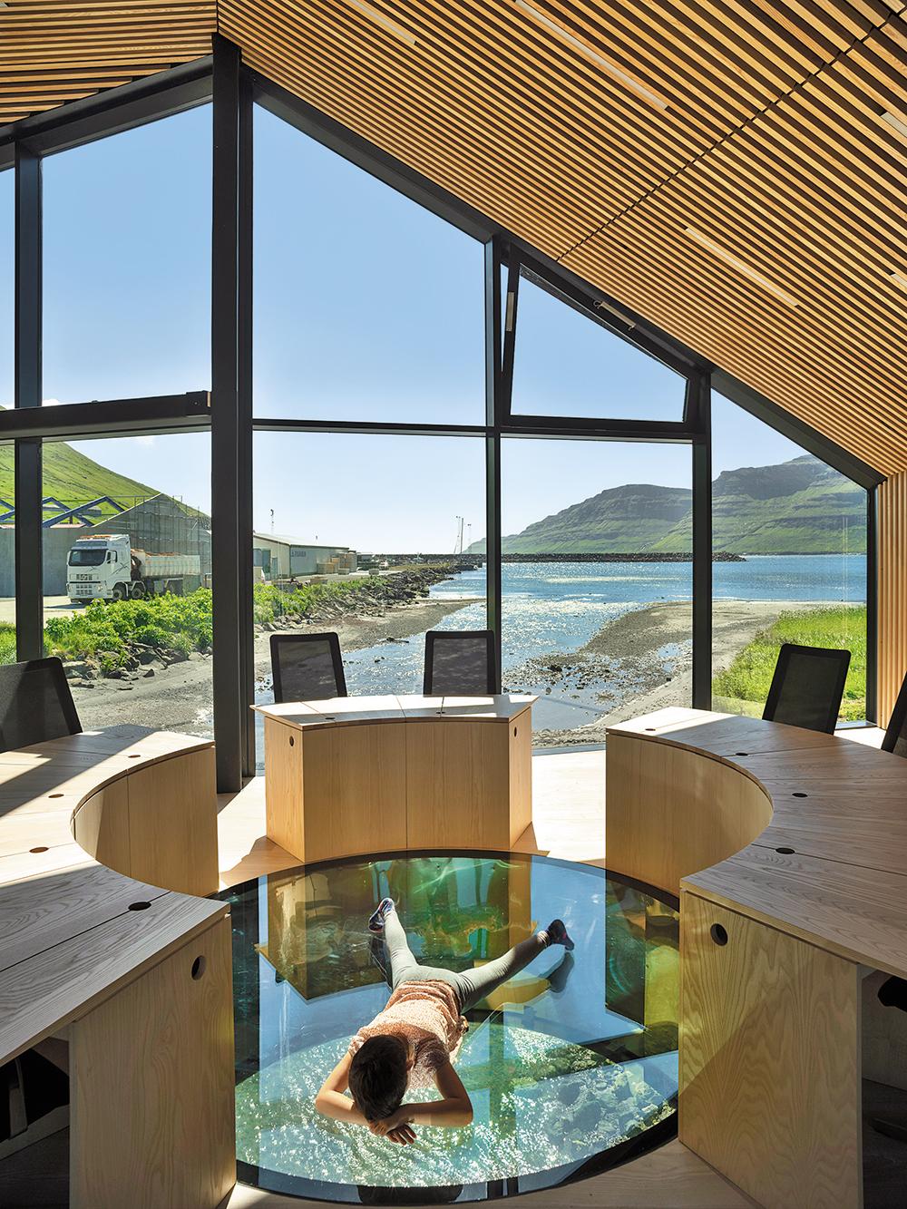 The council chamber over the river relates to the water in two ways: sideways through the full-height window front and downwards through the glazed opening in the floor.