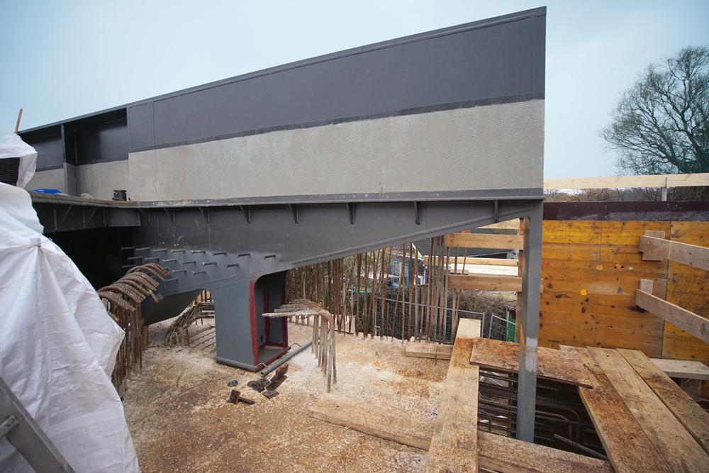 Der Ersatzneubau der Eisenbahnbrücke Lange-Feld-Straße, Hannover, ist ein neuer Brückentyp für die Deutsche Bahn: Der extrem schiefwinklige Stahltrogüberbau wurde monolithisch mit dem Widerlager verbunden, um bei der Stützweite die Konstruktionshöhe zu optimieren und komplizierte Lager mit Zugverankerungen zu vermeiden.