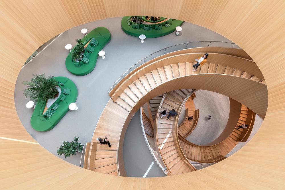 Ringförmige Treppen verbinden die fünf Geschosse. Beim Blick ins Atrium ergibt sich eine optische Durchdringung analog zu den olympischen Ringen.