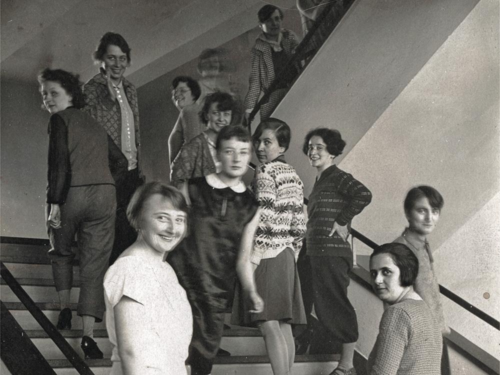 Frauen auf der Treppe des Bauhaus in Dessau: Den Studentinnen stand bis auf wenige Ausnahmen nur die Weberei-Werkstatt offen. Sie wurde auch als „Frauenklasse“ bekannt. Das Foto von T. Lux Feininger von 1927 zeigt die Weberinnen. Vorne links Gunta Stölzl, sie leitete die Weberei ab 1927 als Jungmeisterin.