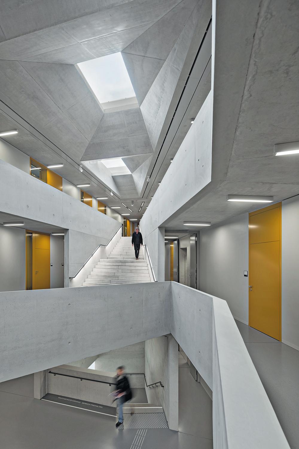 Das Atrium in den drei Obergeschossen verleiht dem kompakten Gebäude Großzügigkeit. Die Treppenläufe sind so angelegt, dass beim Weg hinauf fast das ganze Haus durchschritten wird.