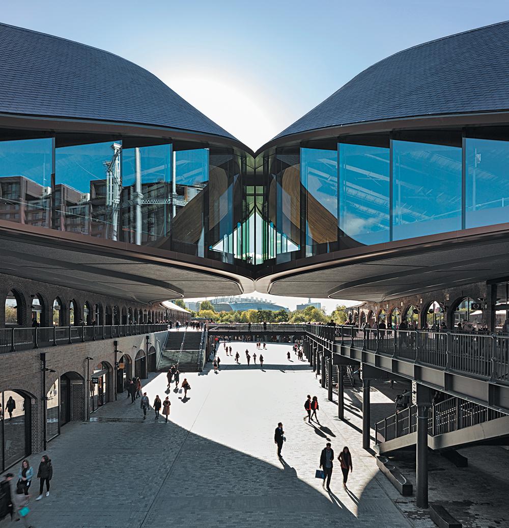 nennen die Architekten liebevoll das Berühren der beiden geschwungenen Dächer über dem Bereich zwischen den Bestandsgebäuden.